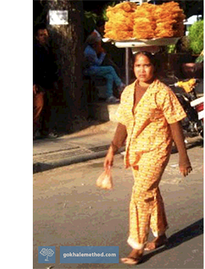 Women in Cambodia walking headloading food. 